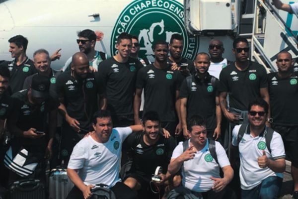 Foto de vários jogadores de futebol perfilados na frente de um avião - Metrópoles