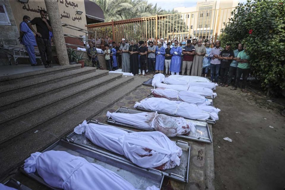 Pessoas rezam no necrotério do Hospital Nasser, após parentes perderem a vida em ataques aéreos israelenses - Metrópoles