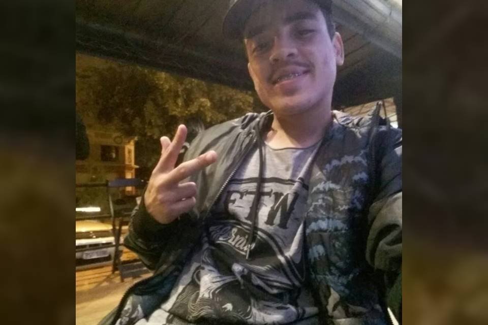 Islan Nogueira, jovem morto em blitz da PMDF. Jovem faz símbolo de paz com as mãos. Rapaz usa boné preto e casaco camuflado - Metrópoles