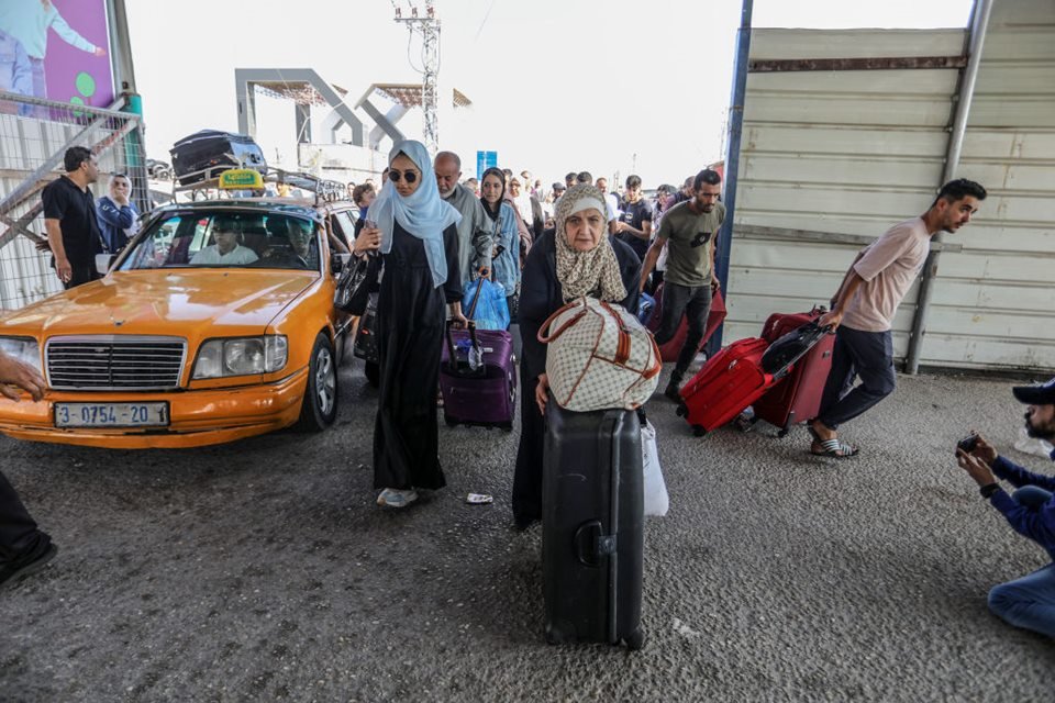 Imagem colorida mostra Palestinos com passaportes estrangeiros no Portão Fronteiriço de Rafah esperam para cruzar para o Egito enquanto os ataques aéreos israelenses continuam - Metrópoles