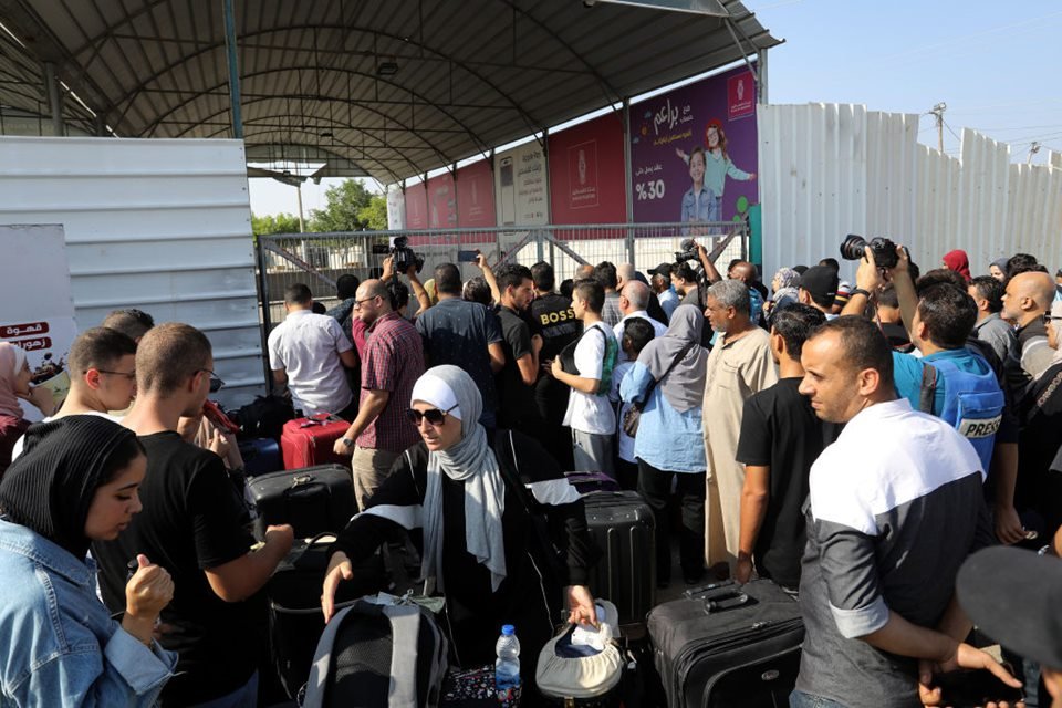 Imagem colorida mostra Palestinos esperando para cruzar o portão fronteiriço de Rafah em Gaza - Metrópoles