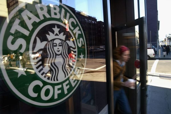 Imagem da porte de uma loja da Starbucks, com uma pessoa saindo - Metrópoles