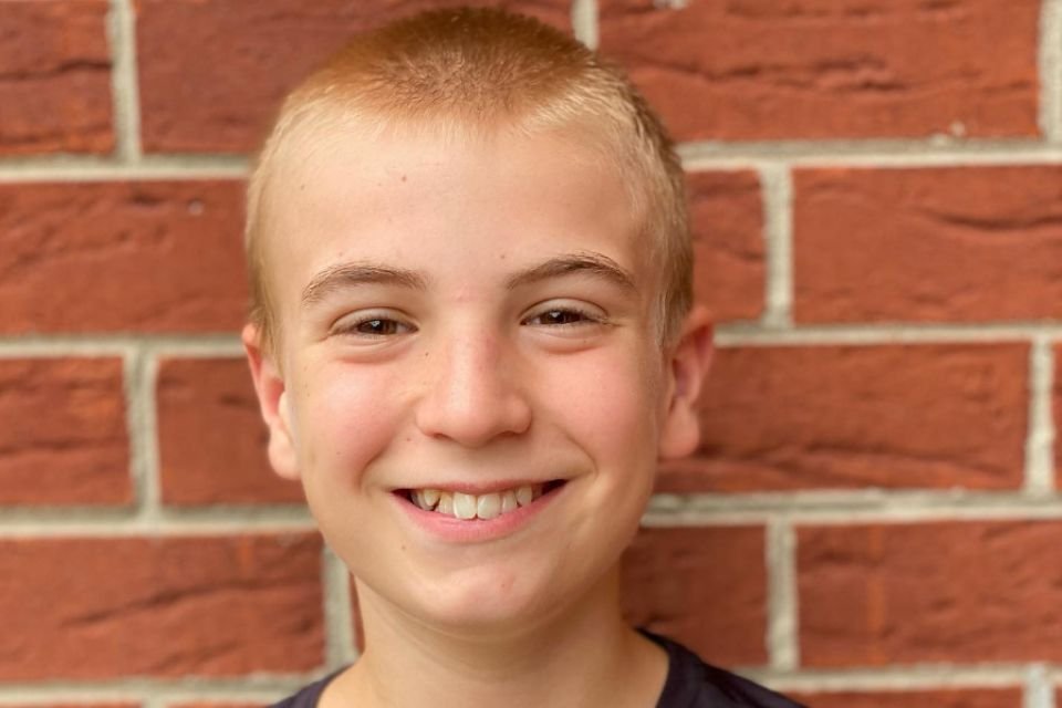 Foto colorida de um menino sorrindo - Metrópoles