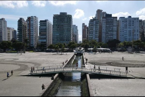 Imagem colorida de orla da praia de Santos, na Baixada Santista; cidade está tendo surto de coceira - Metrópoles