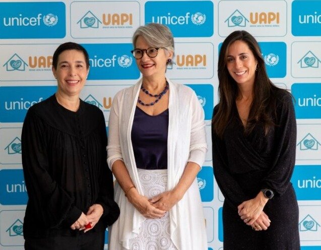 Imagem de três mulheres brancas. No centro está Luciana Phebo, chefe de Saúde do Unicef