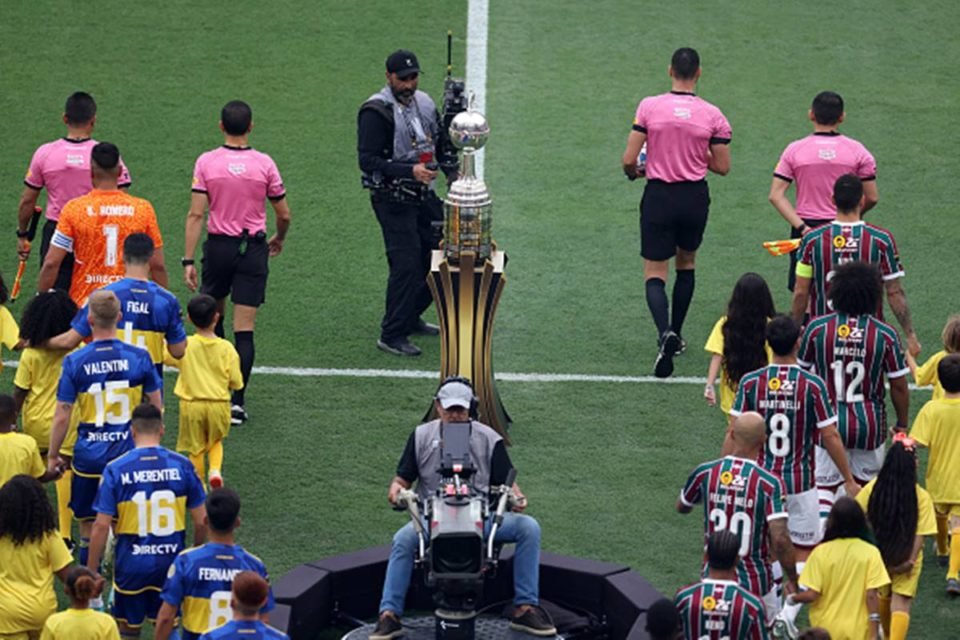 Imagem colorida de de jogadores do Fluminense e jogadores do Boca Juniors entrando em campo pela final da Libetadores - Metrópoles