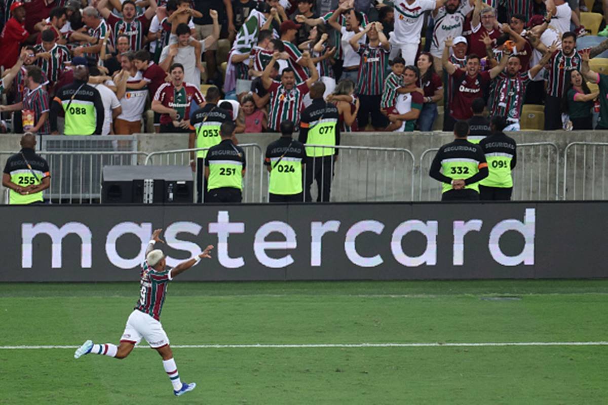 Imagem colorida de jogador do Fluminense correndo em direção a torcida para comemorar gol
