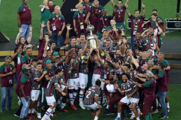 Imagem mostra jogadores do Fluminense comemorando com a taça da Libertadores - Metrópoles