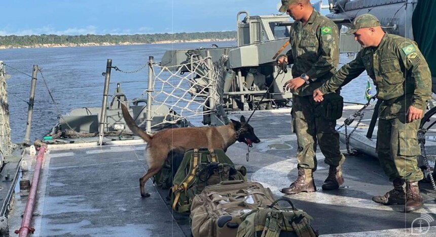 Em foto colorida fuzileiros navais com cachorro em navio - Metrópoles