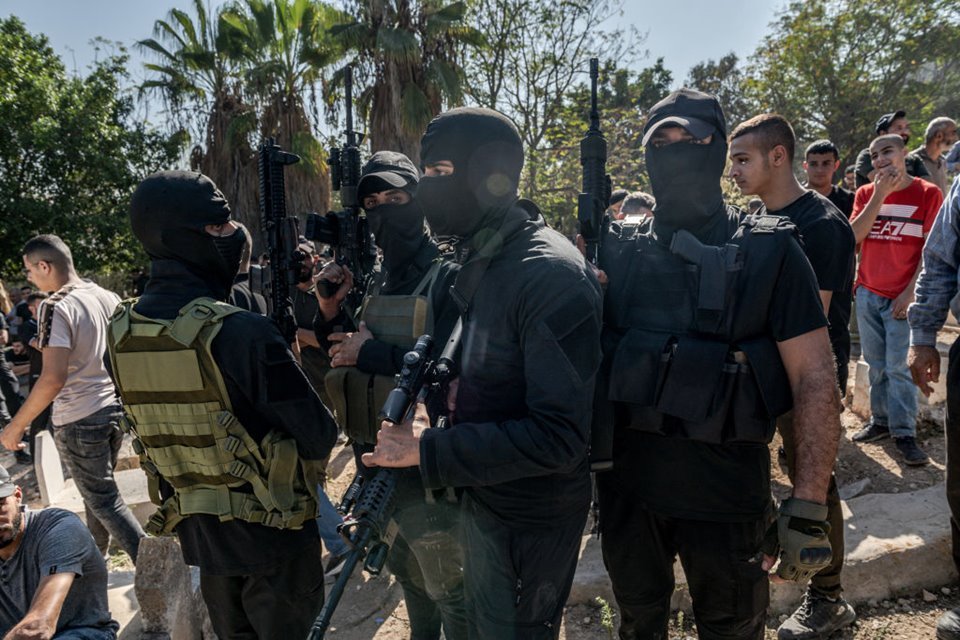 Imagem colorida mostra Milicianos mascarados do Hamas carregam suas armas durante o funeral de quatro jovens mortos pelo exército israelense em um ataque à cidade de Tulkarm - Metrópoles