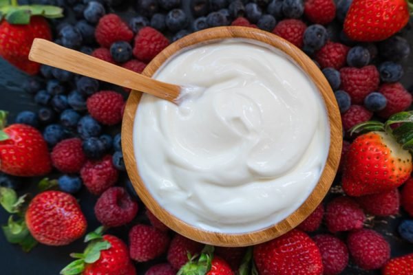 Foto colorida de bowl com iogurte dentro e ao redor, frutas vermelhas - Metrópoles