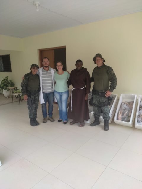 foto colorida dos 125 quilos de peixes apreendidos pela Polícia Ambiental e doados a um centro de recuperação de dependentes químicos em SP; imagem de funcionários do Lar Nossa Senhora do Carmo, que recebeu os peixes - Metrópoles