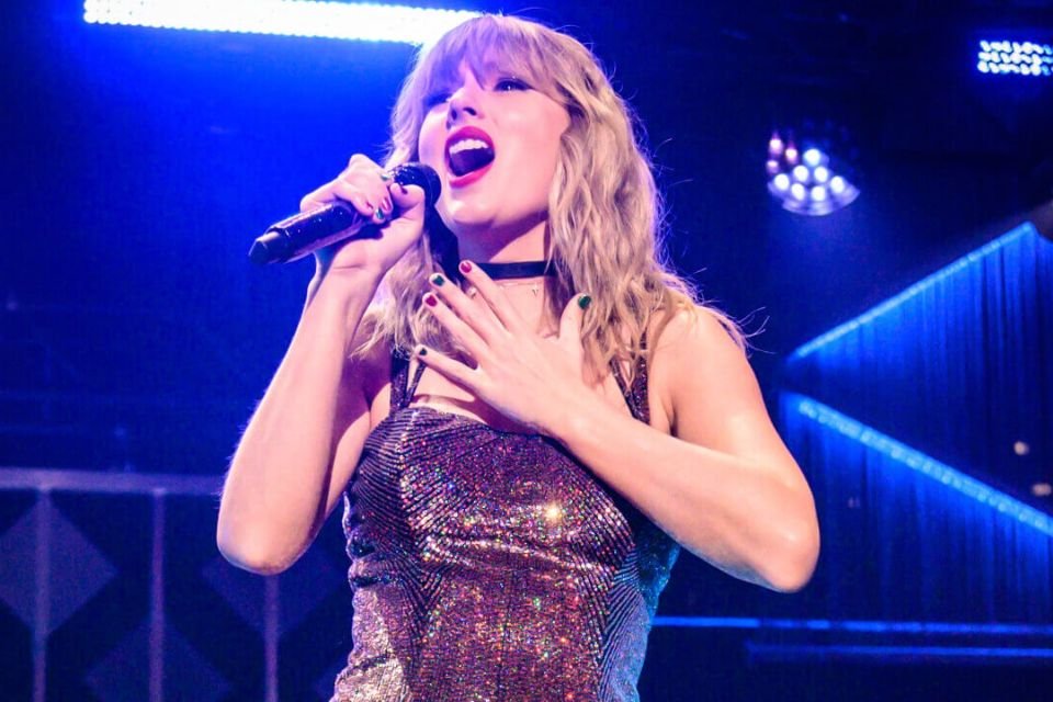 Foto mostra a cantora Taylor Swift em primeiro plano