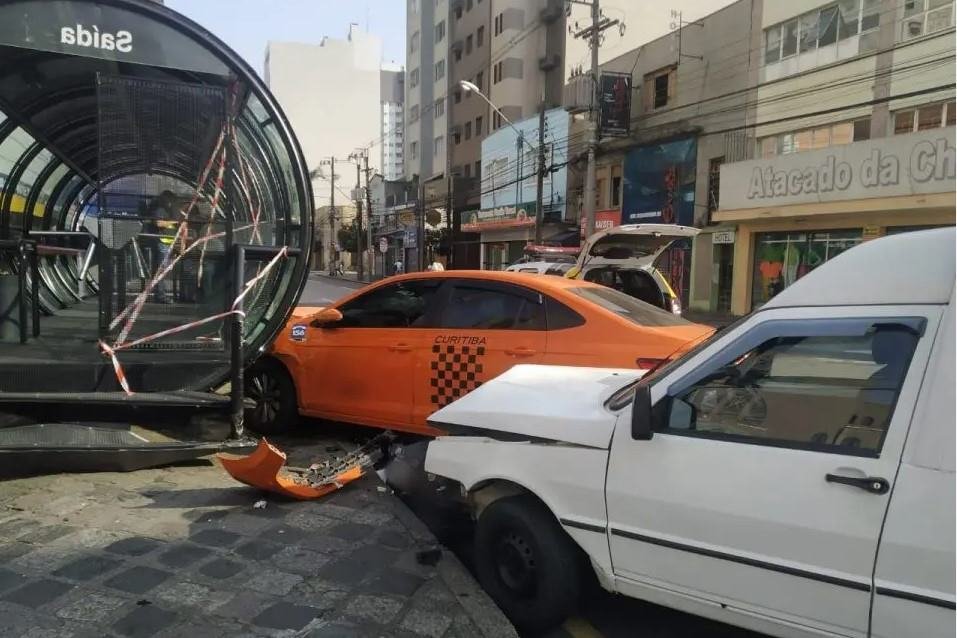 Foto de acidente de trânsito no centro de Curitiba com táxi laranja atingido por Fiorino