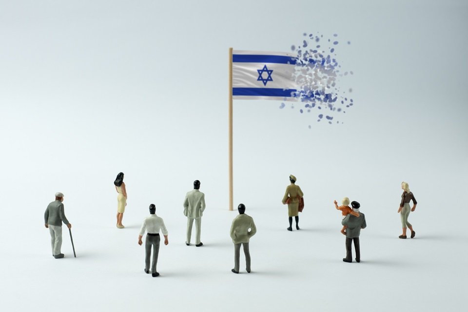 Imagem colorida da bandeira de Israel se desmanchando, observada por várias pessoas, ilustrando a população do país - Metrópoles