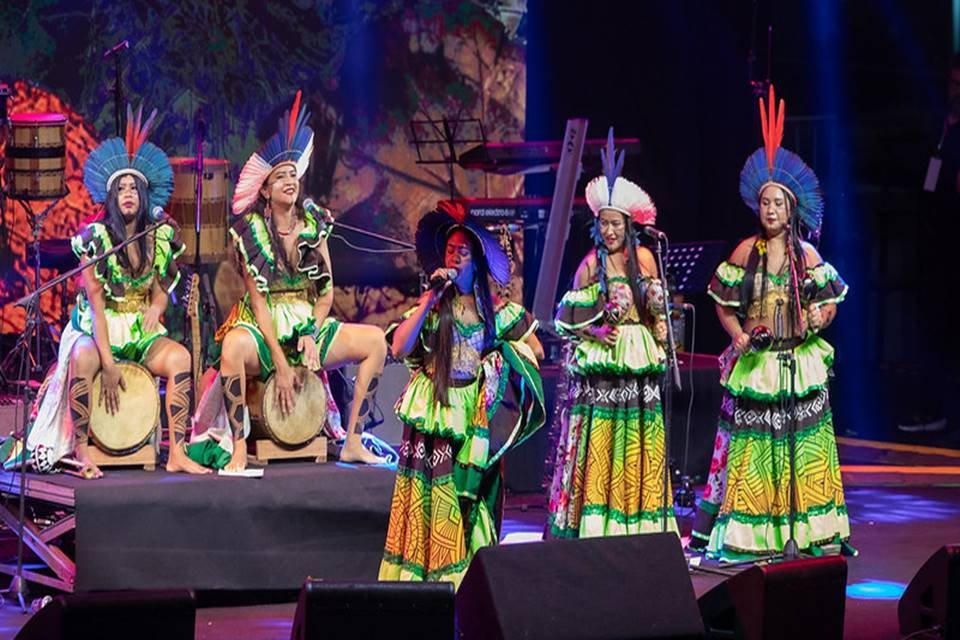 foto colorida de grupo musical de mulheres indígenas em apresentação