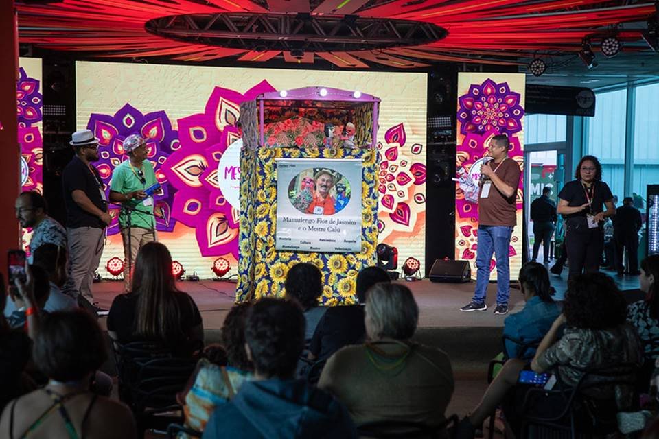 Foto colorida de palco com a apresentação de teatro de bonecos