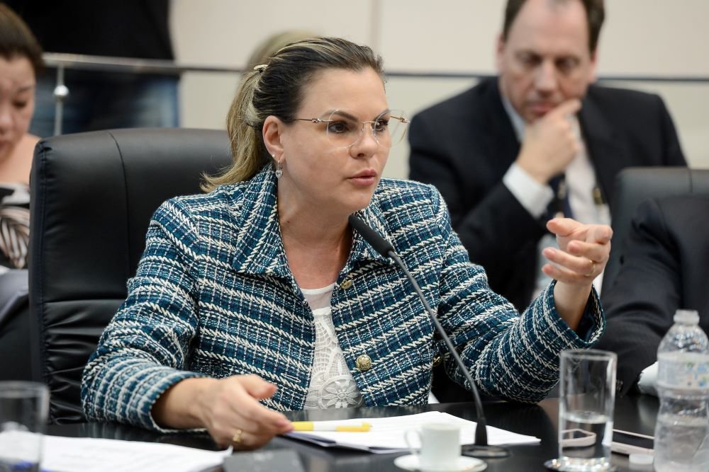 Fotografia colorida mostra a deputada estadual Carla Morando (PSDB), relatora da CPI da Enel, uma mulher branca usando rabo de cavalo, óculos e paletó azul - Metrópoles