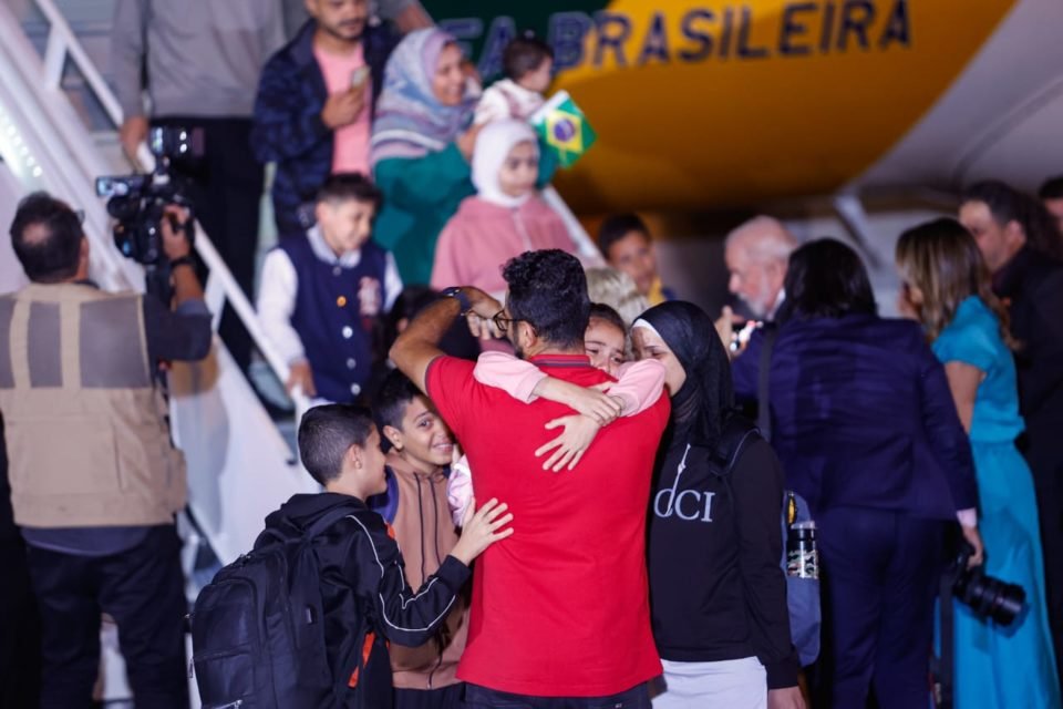Crianças abraçam homem após repatriação - Metrópoles