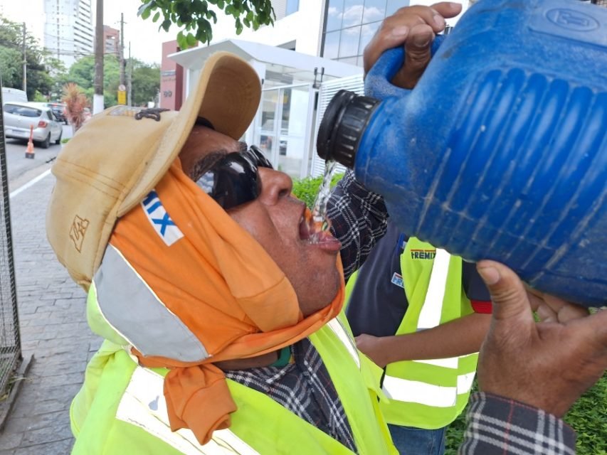 Imagem mostra trabalhador bebendo água em meio ao calor - Metrópoles