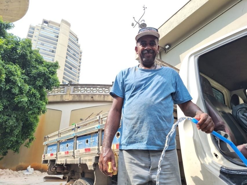 Imagem mostra homem segurando mangueira com água - Metrópoles