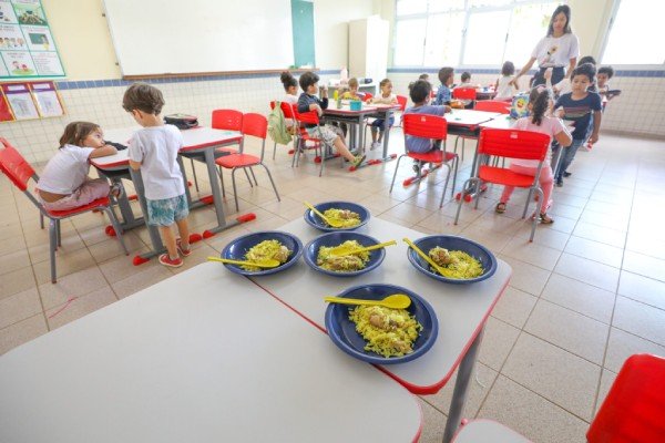 Fotografia colorida mostrando alunos comendo em escola-Metrópoles