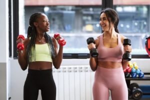 duas mulheres segurando peso na academia