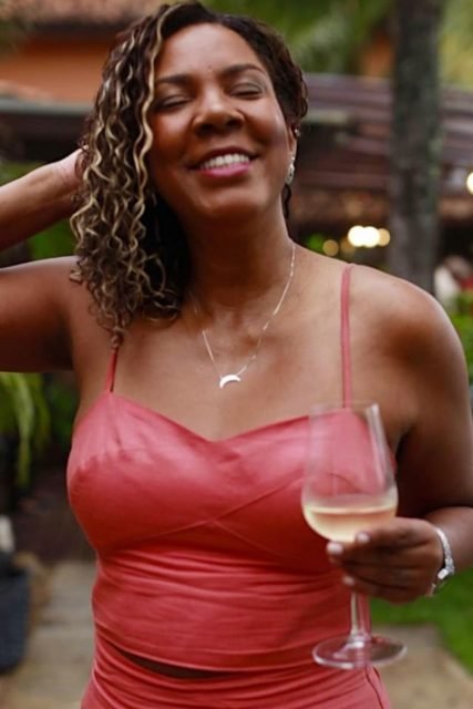 Foto colorida de uma mulher bebendo champagne - Metrópoles