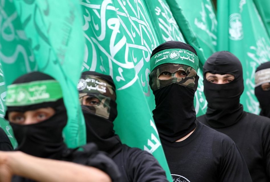 Imagem colorida mostra membros do Hamas usando balaclavas e segurando bandeiras do grupo - Metrópoles