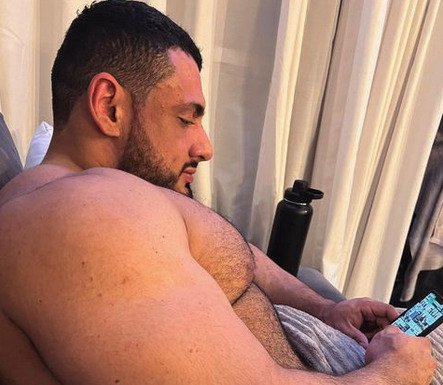 Imagem de homem sem camisa olhando para celular - Metrópoles