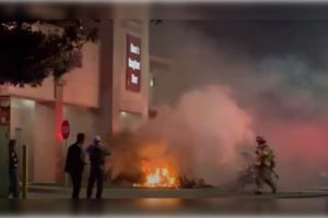 Imagem colorida mostra bombeiros apagando incêndio em avião que caiu em frente a shopping nos EUA - Metrópoles