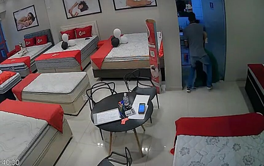 Em imagem colorida homem conduz mulher, segurando os braços dela, para dentro de lavabo - Metrópoles