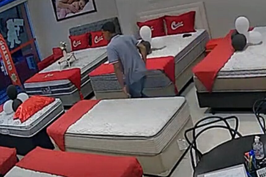 EM imagem colorida homem de calça jeans e camiseta grafite correm em meio a camas em loja de colchões - Metrópoles