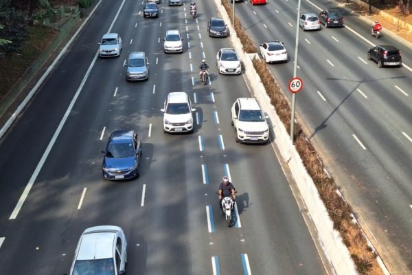 Imagem mostra avenida com carros e motos com uma faixa especial para motos - Metrópoles