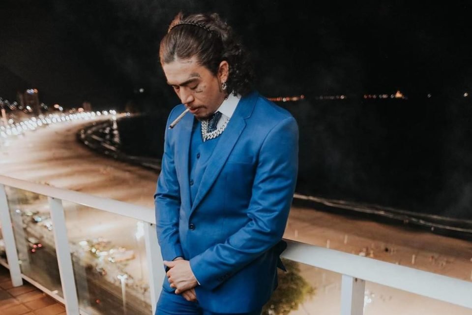 foto colorida de whindersson nunes de terno azul fumando cigarro - metrópoles