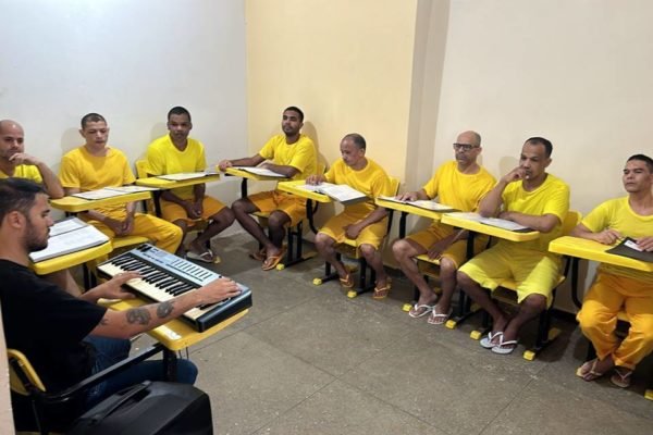 Imagem colorida de homens sentados com camisas amarelas