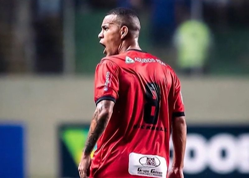 Imagem colorida de jogador de futebol com uniforme vermelho, de costas - Metrópoles