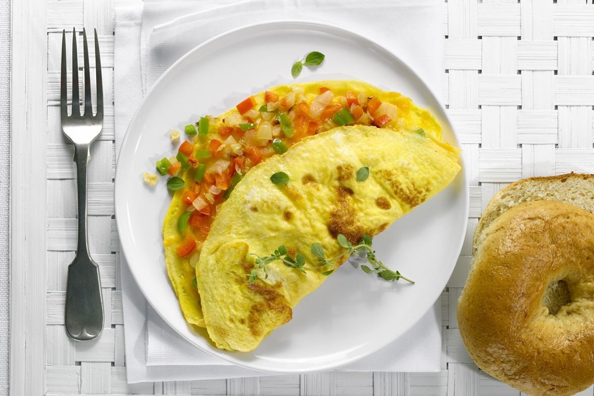Foto colorida de omelete com legumes em um prato branco - Metr&oacute;poles
