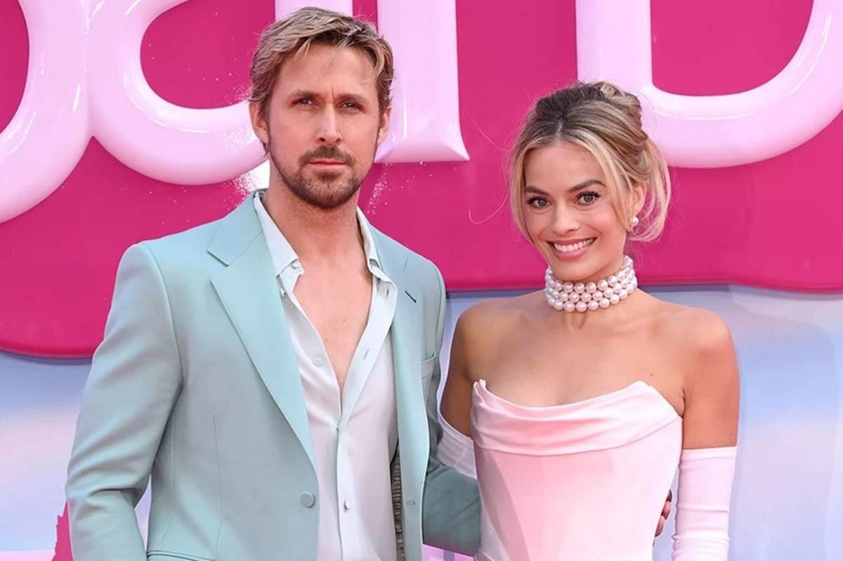 Foto colorida de Ryan Gosling e Margot Robbie lado a lado com a logo do filme Barbie ao fundo - Metrópoles