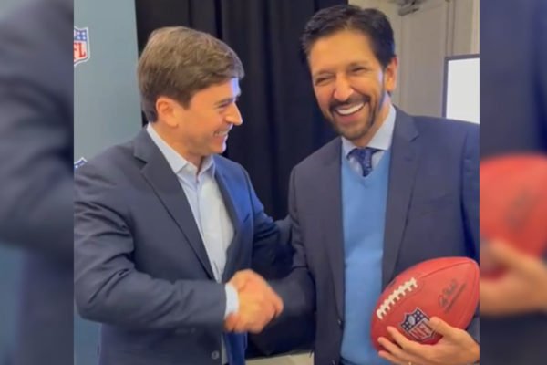 Fotografia colorida mostra comissário da NFL, Roger Goodell, apertando a mão do prefeito de SP, Ricardo Nunes, que segura uma bola de futebol americano - Metrópoles