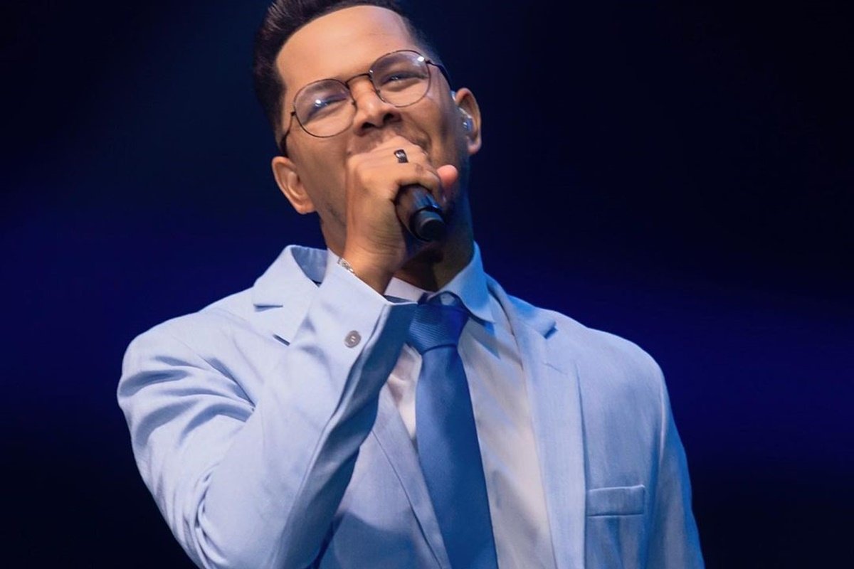 O cantor gospel Pedro Henrique canta usando terno azul claro - Metrópoles