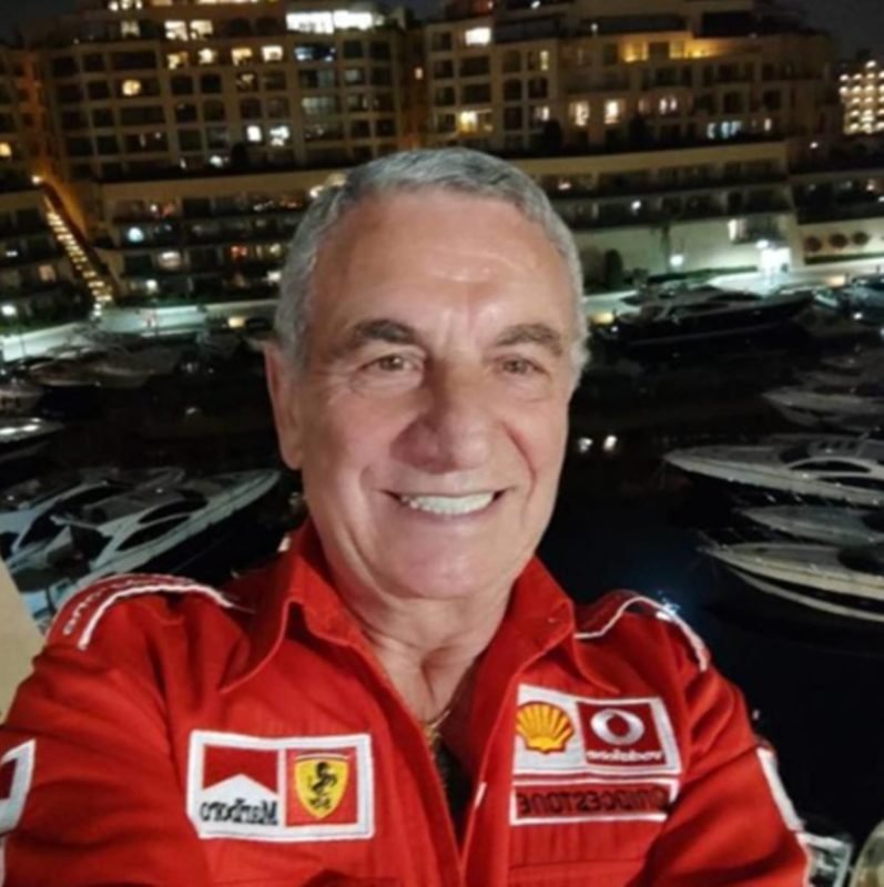 homem sorrindo com camisa da Ferrari