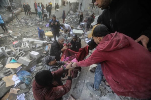 imagem colorida mostra pessoas retirando corpos de escombros após bombardeio na faixa de gaza - Metrópoles