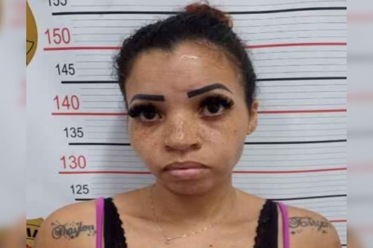 Imagem colorida de mulher presa na dleegacia. Ela está com o cabeço preso e camiseta - Metrópoles