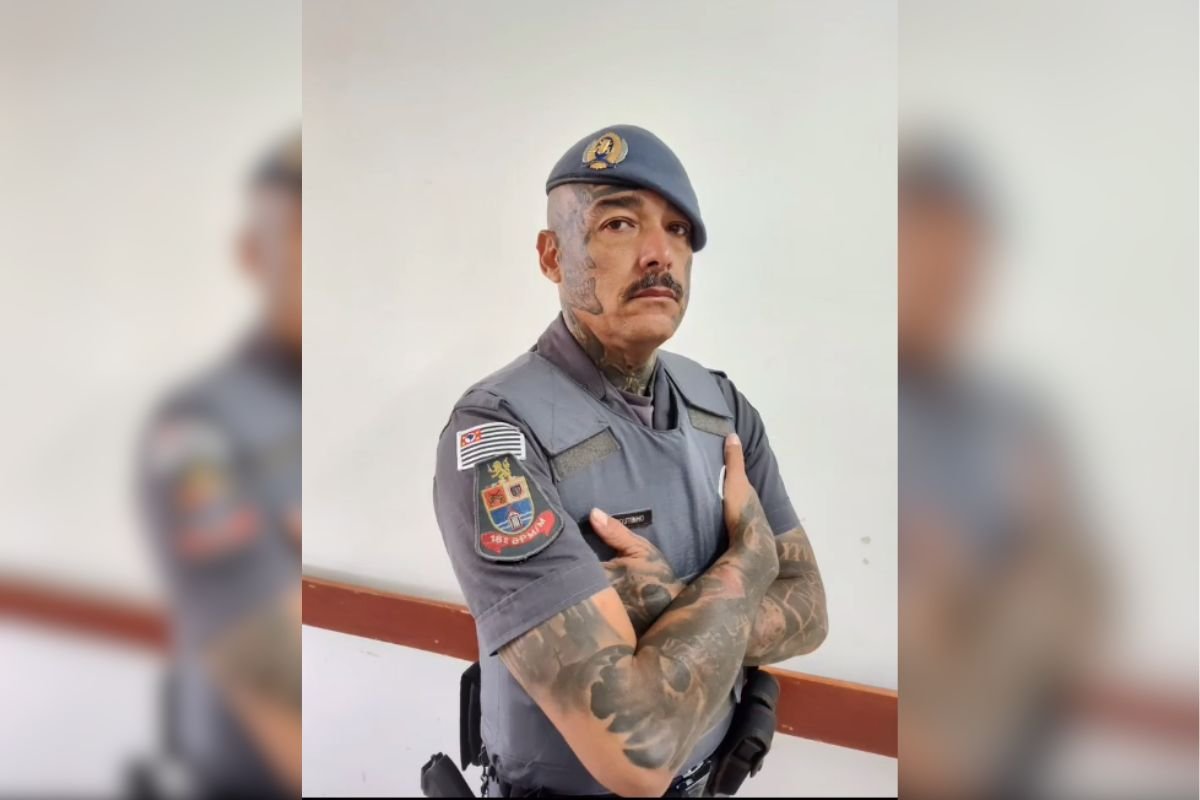 imagem colorida mostra soldado da policia militar. ele tem o braço e rosto tatuados - metrópoles