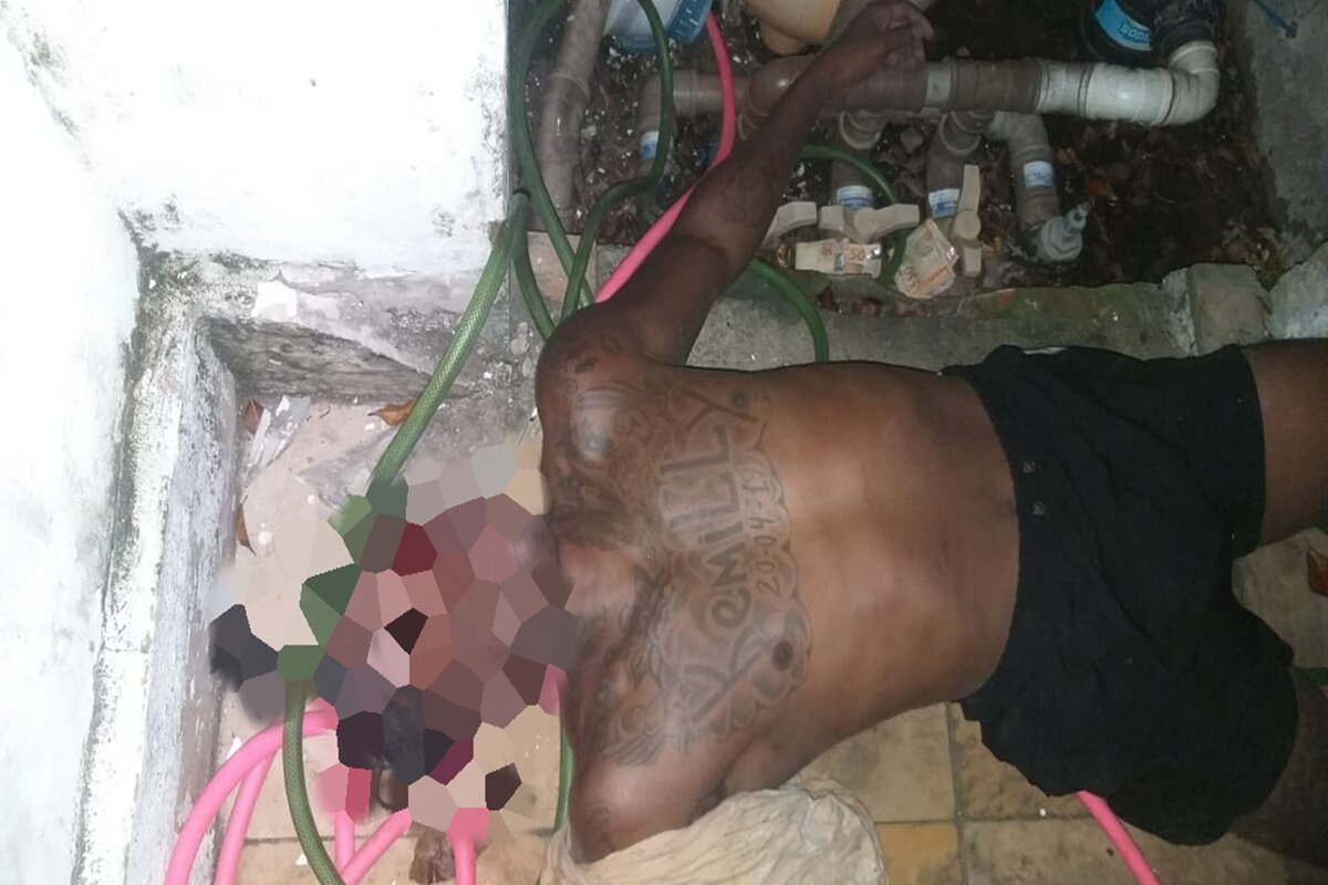 Imagem colorida de homem preto caído morto no chão, com tatuagem no peito com o nome Kemilly - Metrópoles