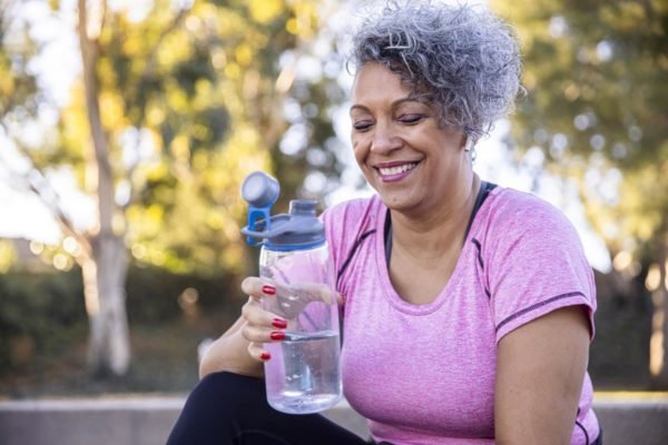 Foto colorida de uma mulher bebendo água - Metrópoles