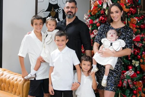 Leticia, grávida, e Juliano Cazarré posam com os cinco filhos em frente à árvore de Natal - Metrópoles