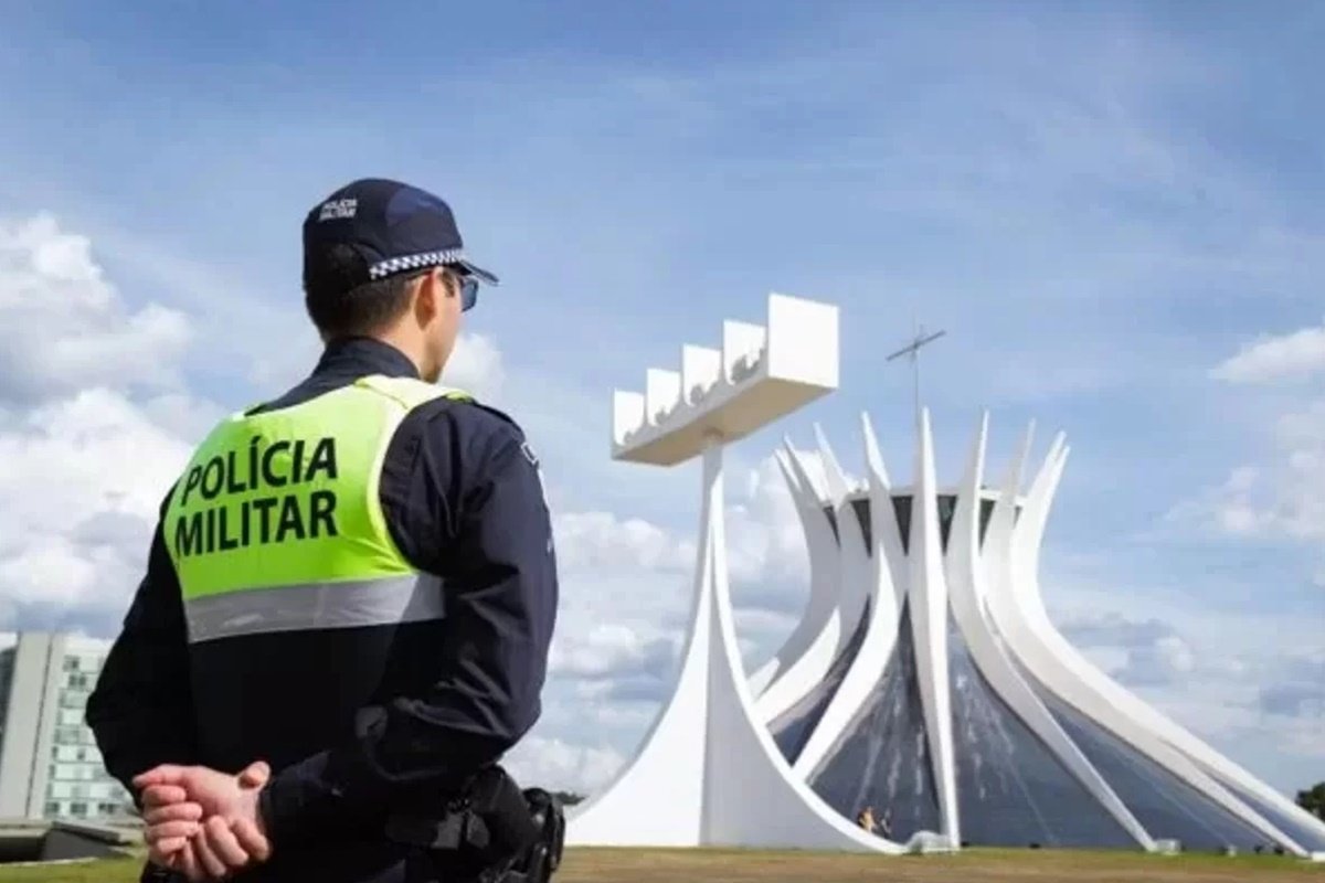 Fotografia colorida mostrando PM de costas olhando para a Catedral-Metrópoles