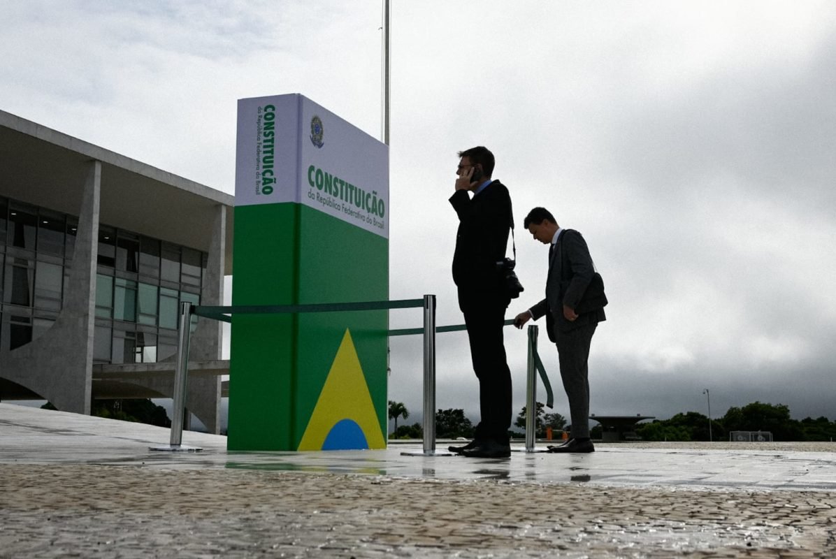 Seguranças em frente a réplica gigante da Constituição colocada em frente ao Palácio do Planalto